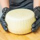Persona con guantes negros tocando un queso de Quesos Bolaños en Gran Canaria