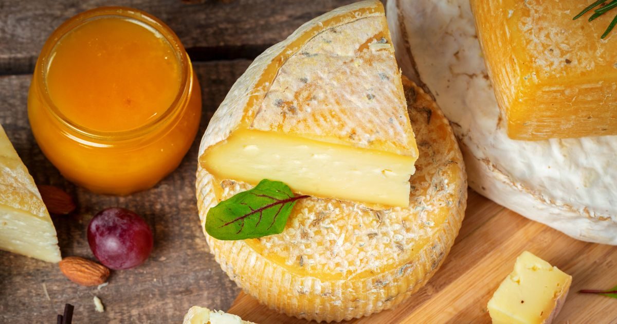 Queso cortado encima de otro de Quesos Bolaños al lado de un tarro de miel en Gran Canaria