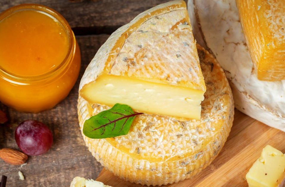 Queso cortado encima de otro de Quesos Bolaños al lado de un tarro de miel en Gran Canaria