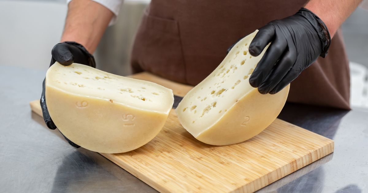 Queso partido por la mitad sobre una tabla de madera de Quesos Bolaños en Gran Canaria